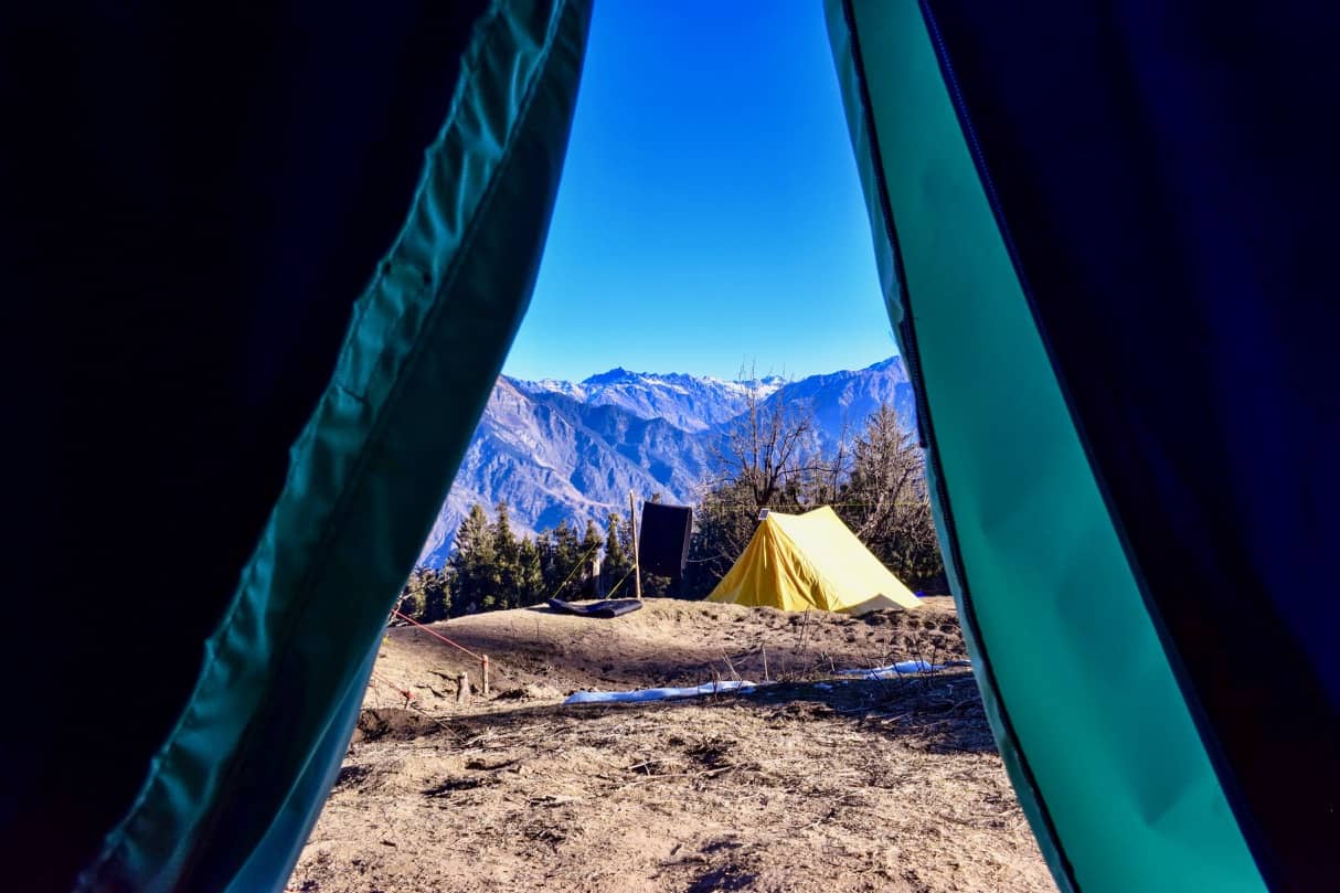 Tents pitched at a winter camping site on a snow trek in Uttarakhand