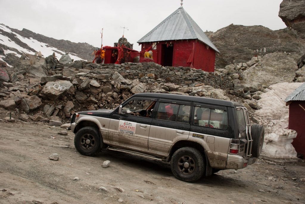 Road to Sach Pass with snow walls and rocky terrain in Himachal Pradesh