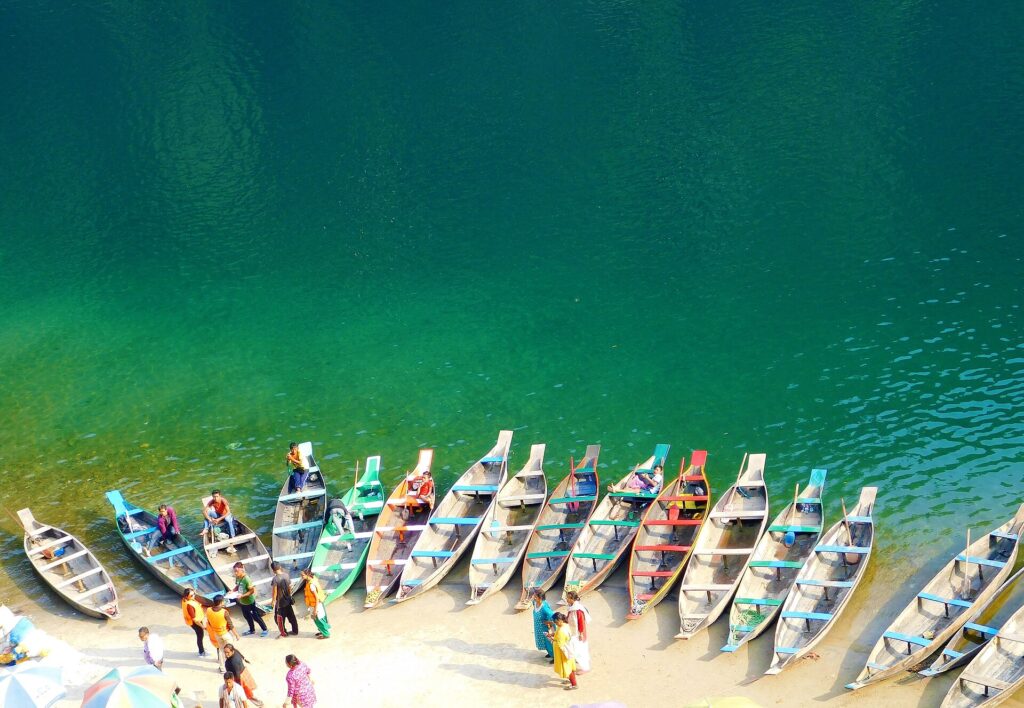 Wooden boats lined up on the clear green Umngot River at Dawki, Meghalaya