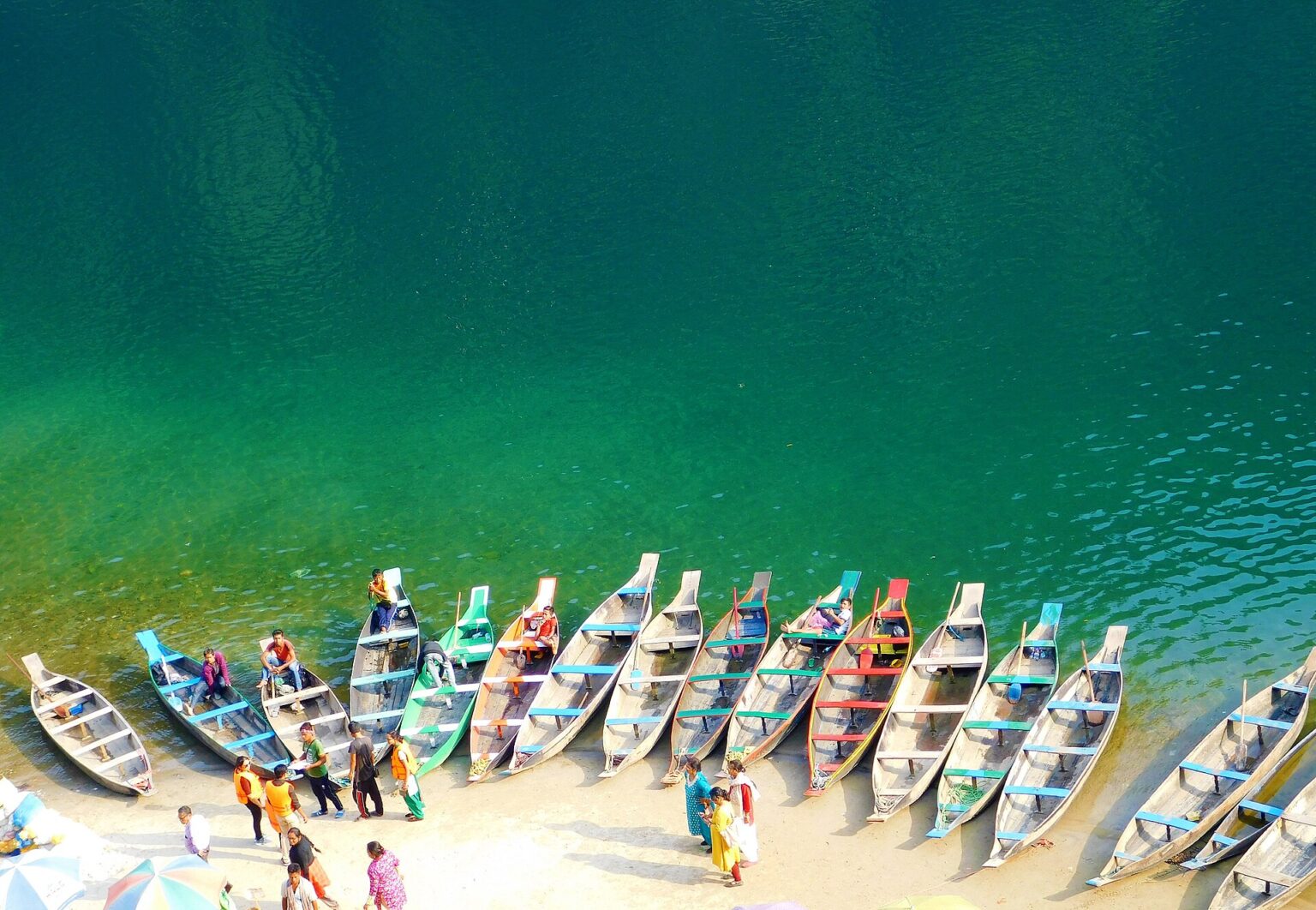 Wooden boats lined up on the clear green Umngot River at Dawki, Meghalaya